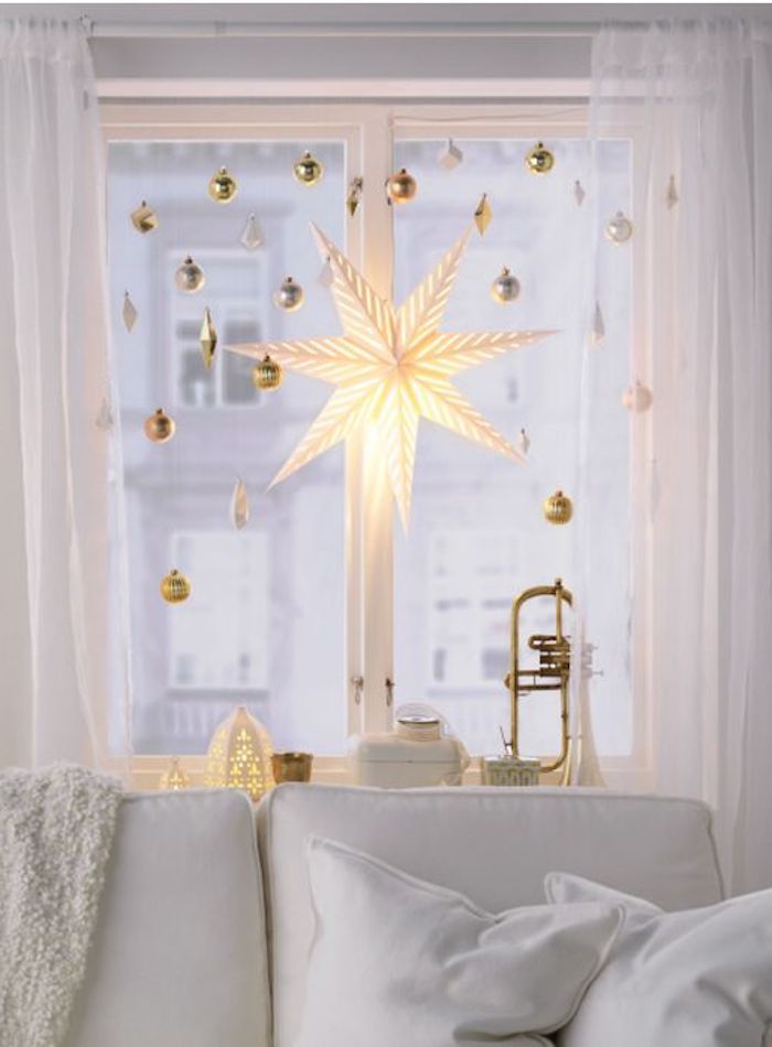 weihnachtliche deko dekorative elemente an dem fenster im wohnzimmer in weißer farbe stern leuchtend festliche laune gestalten