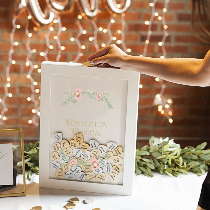 Den eigenen Namen oder Glückwunsch auf kleines Holzherz schreiben, schöne Idee für Hochzeitsgästebuch
