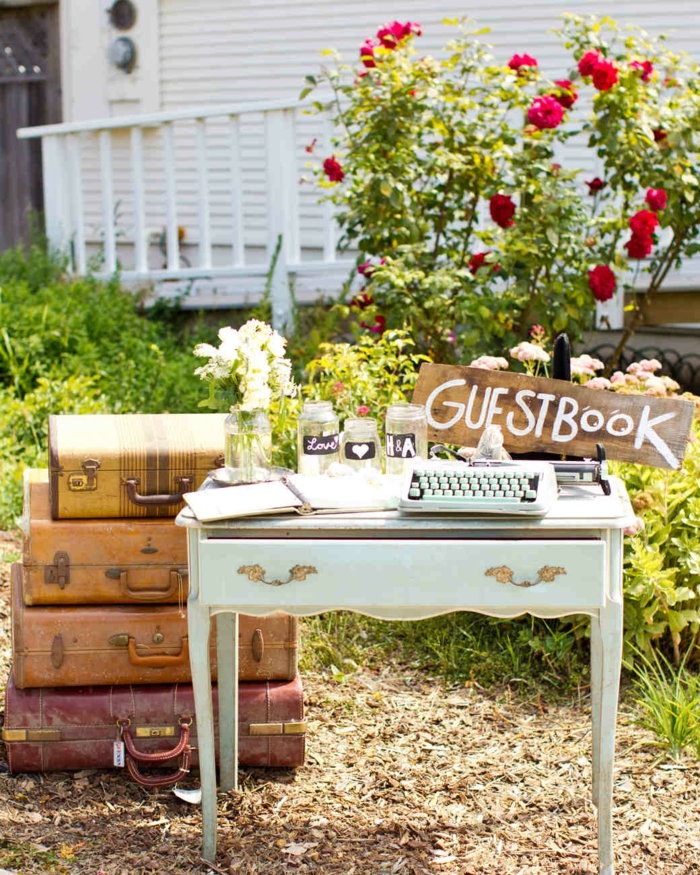 Hochzeit in Vintage Stil, Holztisch mit Altersspuren und Schreibmaschine, altes Heft für Glückwünsche von den Hochzeitsgästen