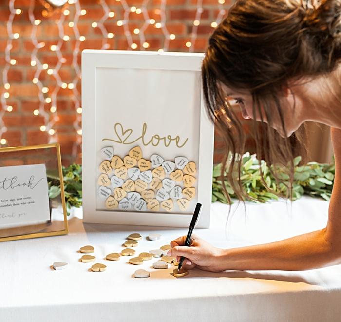 Etwas Romantisches oder Lustiges auf kleines Holzherz schreiben und dem Ehepaar schenken, Idee für Hochzeitsgästebuch