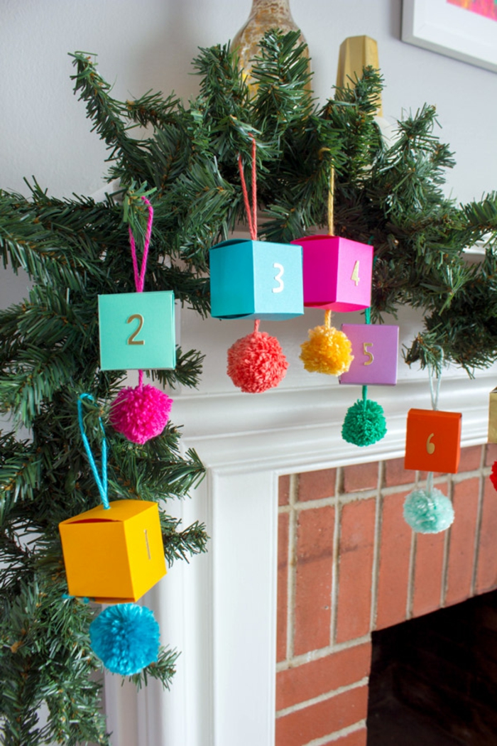 Tannengirlande mit kleinen Schachteln verziert, voll mit Spielzeugen und Süßigkeiten, Kamin weihnachtlich dekorieren