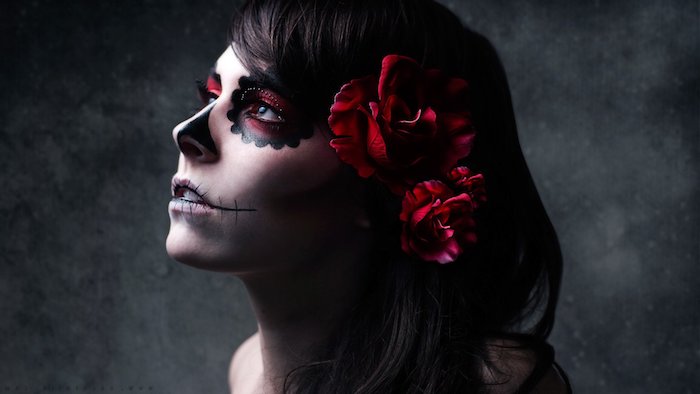 junge frau mit schwarzen augen und einer schwarzen nase und drei großen roten rosen - la catrina schminken