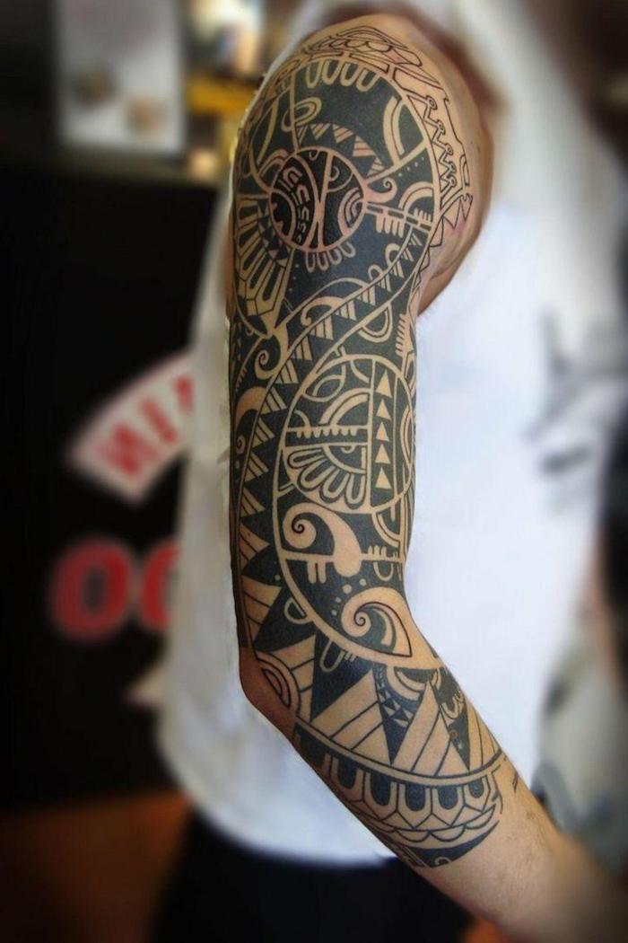 maorie tattoo bedeutung - ein mann mit einer hand mit einem großen schwarzen maori tattoo