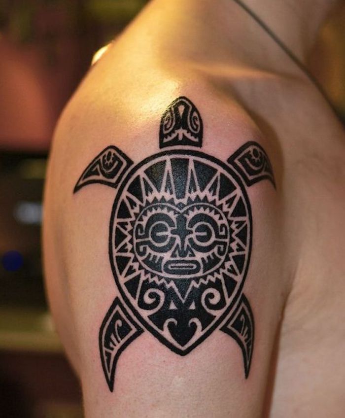 ein junger mann mit einer schwarzen tätowierung mit einer großen schwarzen schildkröte und einer sonne mit schwarzen augen - maorie tattoo arm