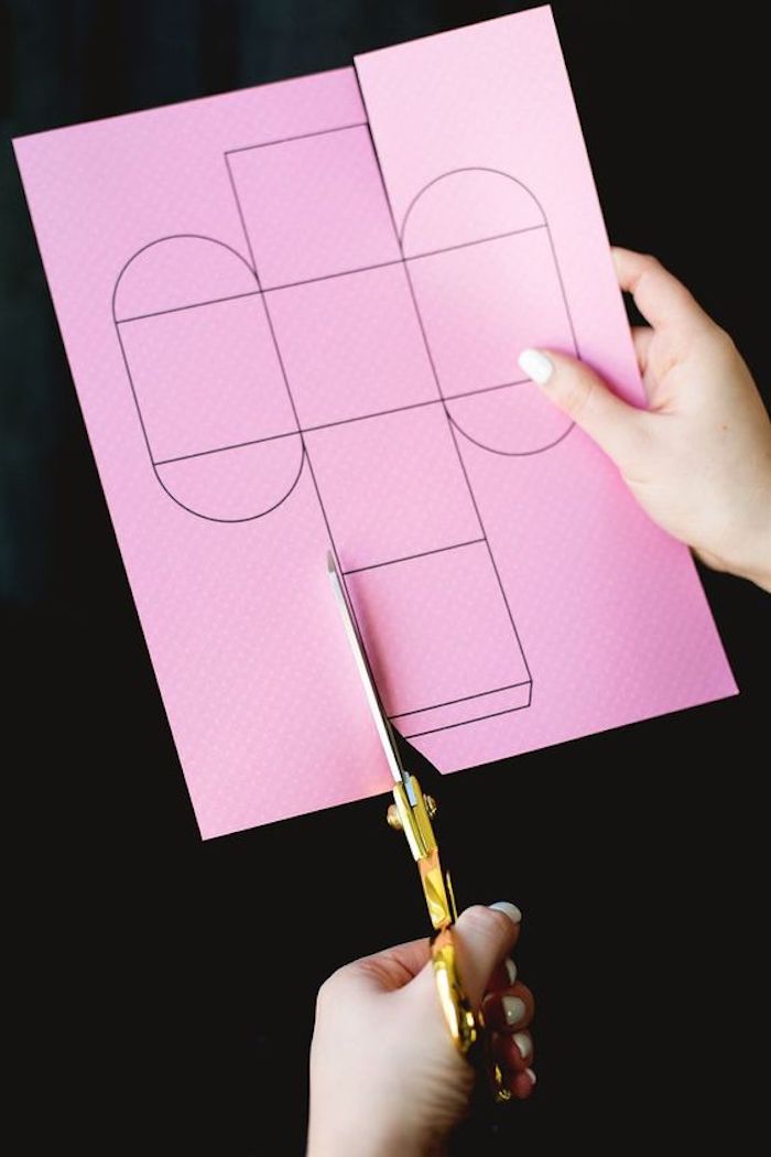 eine Schachtel Vorlage auf rosa Papier mit der Schere schneiden - Pappschachtel