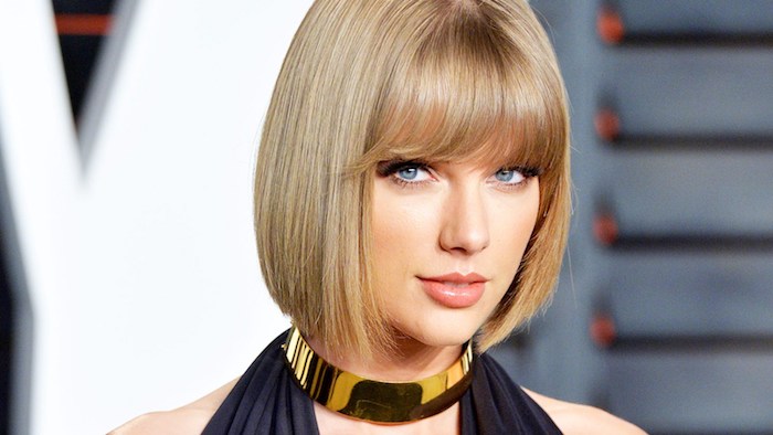 dunkelblonde Haare - Taylor Swift mit Bob Frisur mit Pony, eine Halskette und schwarzes Kleid