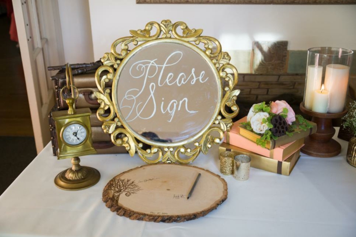 Hochzeit in Landhausstil, Spiegel mit goldenem Rahmen, Holzstück zum Aufschreiben, weiße Kerzen und Bücher