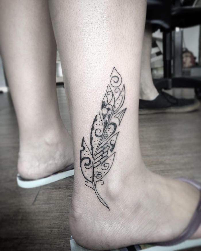 tattoo feder bedeutung, abstrakte schwarz-graue tätowierung am bein