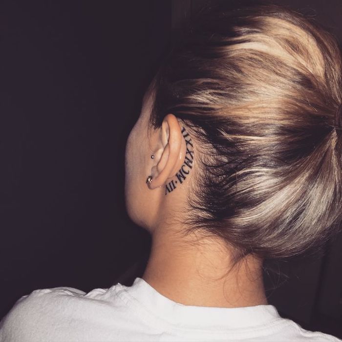 junge frau mit einem schwarzen tattoo hinter ihrem ohr - tattoo hinterm ohr vorlagen