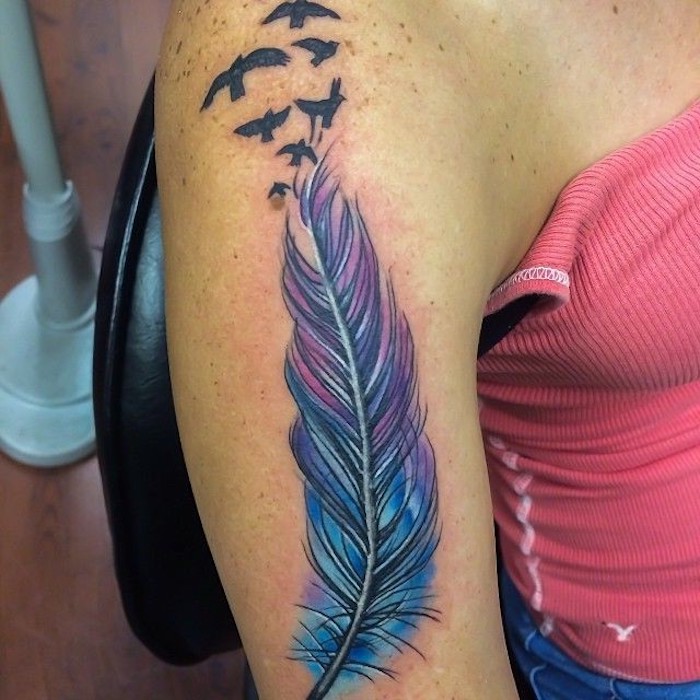 tattoo vogel, frau mit farbiger tätowierung am oberarm