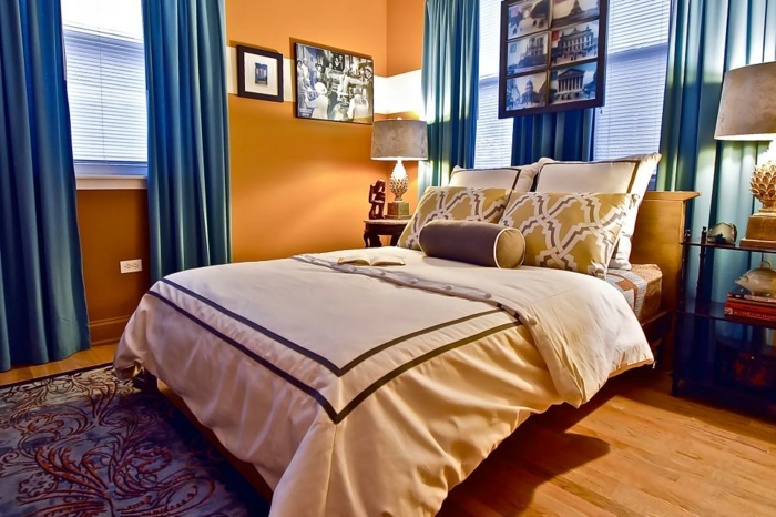 Schlafzimmer Einrichtung in Apricot und Blau, blaue Vorhänge, Wandfarbe Apricot, Bettwäsche in Creme