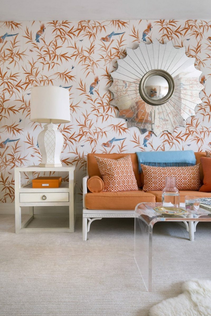 Wohnzimmer Einrichtung in hellen Tönen, Tapeten mit Papageien und Blättern, Sofa in Apricot, schickes Glastisch 
