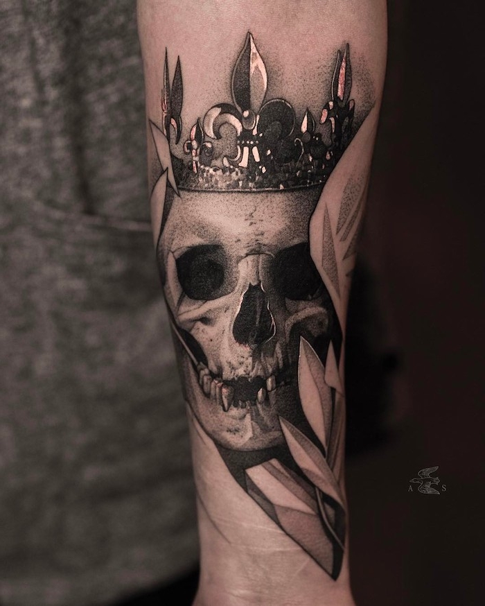 eine hand mit einem großen tattoo mit einem weißen totenkopf mit schwarzen augen und einer krone