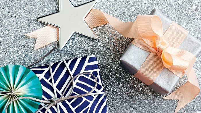 Weihnachtsgeschenke verpacken und verzieren, silbernes Geschenkpapier und apricot Schleife, großer silberner Stern