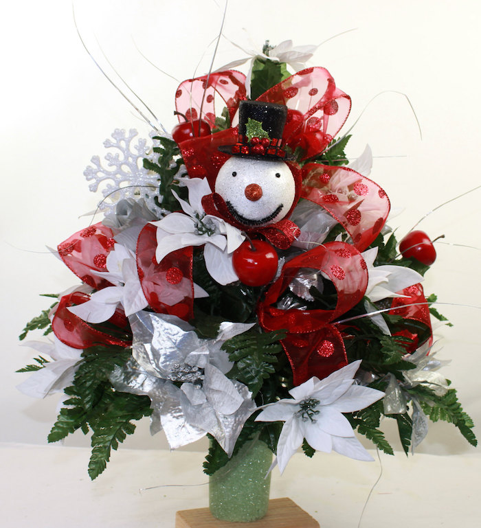 Adventsgestecke Ideen ein Schneemann, künstliche Äpfel, silberne Blumen und rote Schleife
