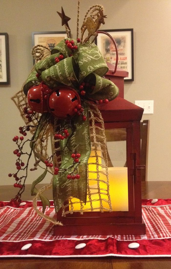 Weihnachtsgesteck aus einer Laterne mit zwei Glocken und eine grüne Schleife