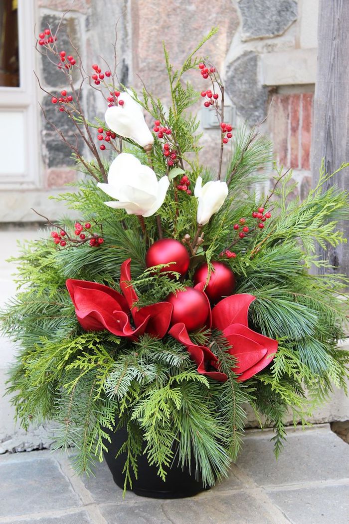 Adventsgestecke aus Naturmaterialien - kleine Zweige aus dem Weihnachtsbaum und weiße Blumen