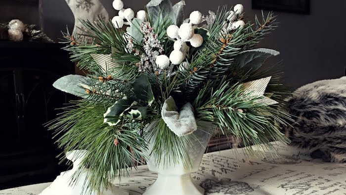 eine weiße Vase mit grünen Tannenzweigen und weiße Blumen - Gestecke selber machen