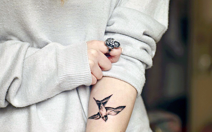 tattoo vogel, frau mit tätowierung mit schwalbe-motiv