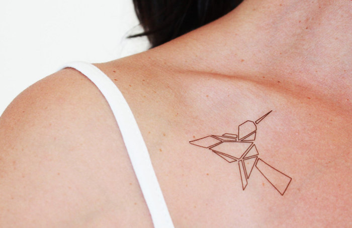 frau mit kolibri tattoo an der brust, origami tattoo