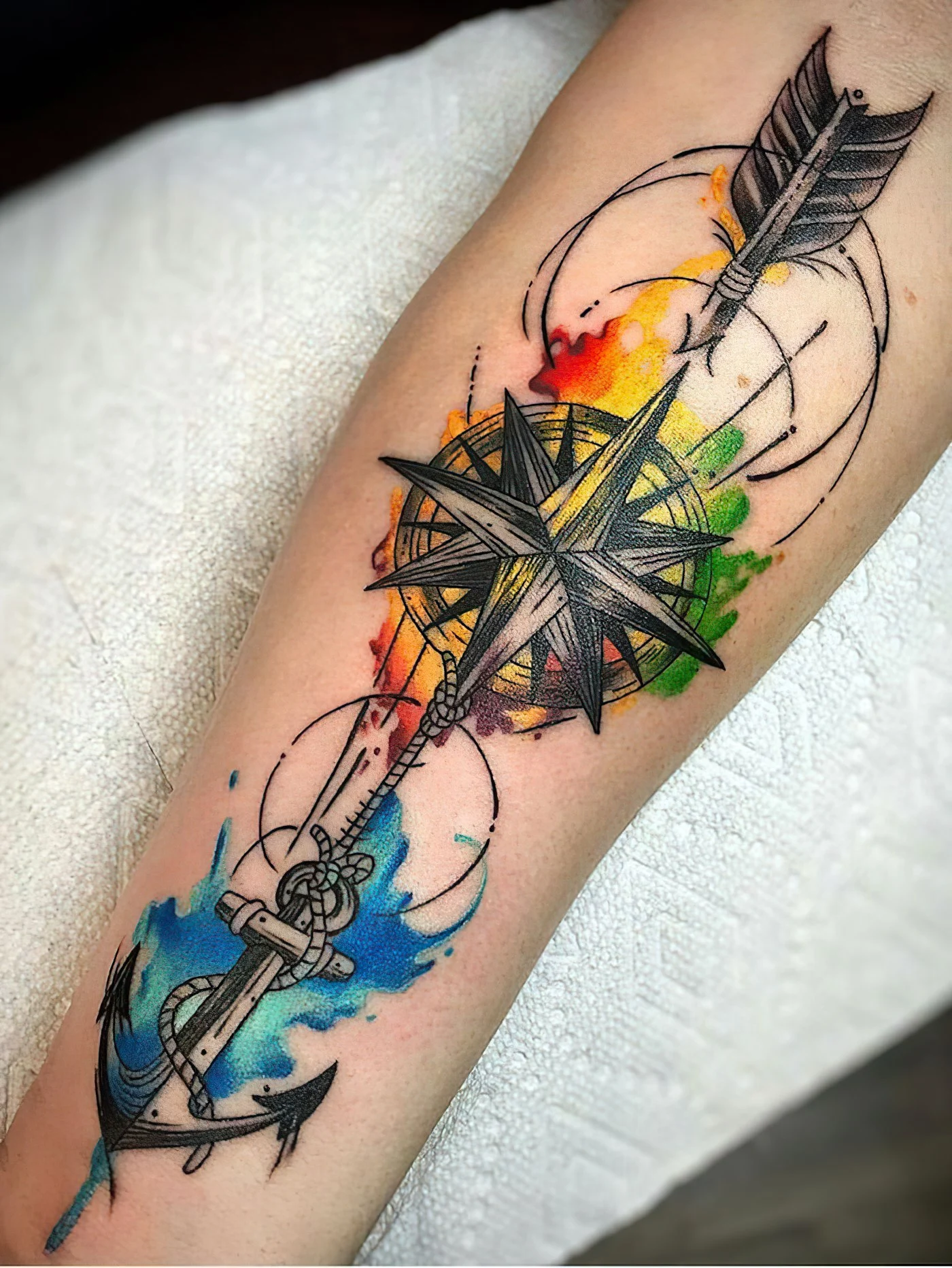 farbiges unterarm tattoo, kompass in kombination mit anker und pfeil