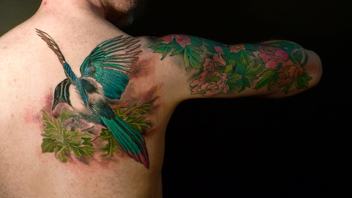 realistisches vogel tattoo am rücken, blumen tattoo am oberarm