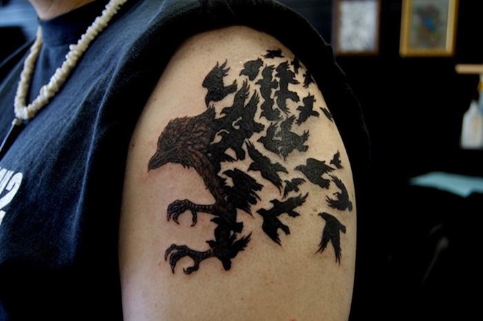 raben tattoo am oberarm, viele fliegende vögel, blackwork