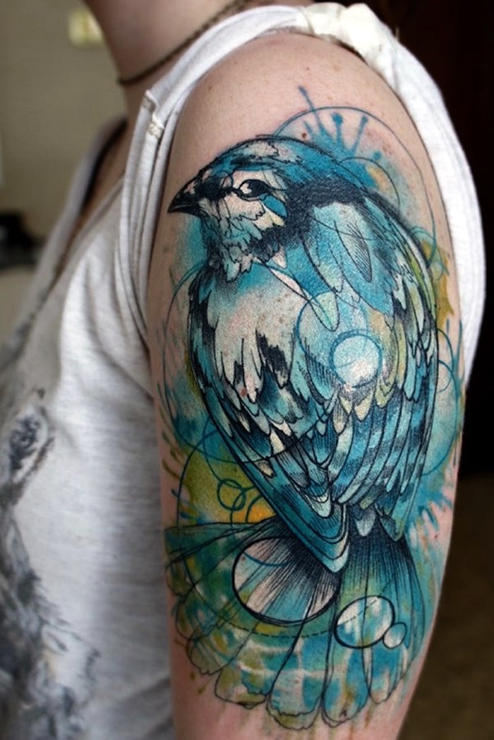 großes farbiges vogel tattoo am oberarm, blaues vogel, wasserfarben