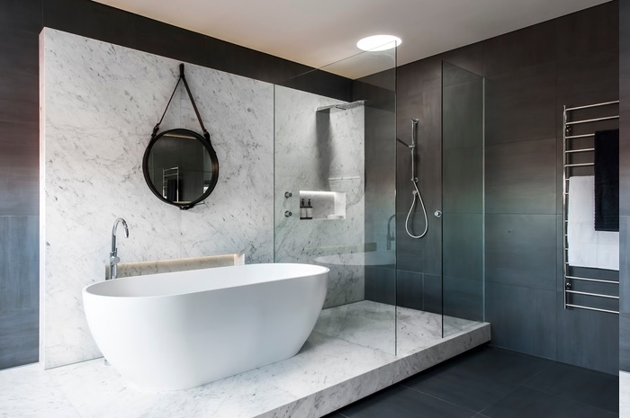 Tuchaufwärmer an der Wand montieren, schwarzer Gesichtstuch und weißer Badetuch, Badezimmer auf zwei Ebenen mit Marmorstufen