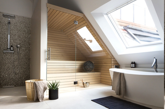 Bad mit Sauna für zwei Personen mit kleinem Dachfenster, schwarze Fußmatte, Wäschekorb aus Holz, Deko mit Aloepflanze