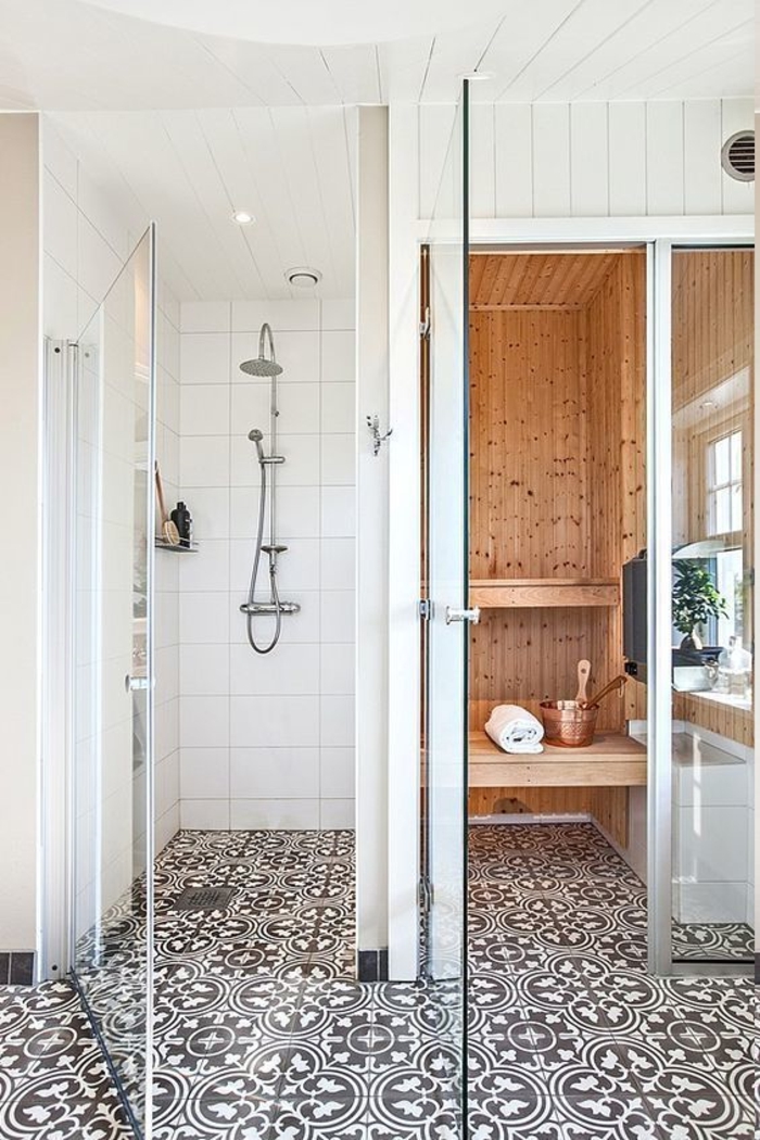 kleines Bad mit ornamentalem Boden, Duschkabine mit Regendusche, Sauna-Kabine mit Fenster, Decke mit Holzverkleidung