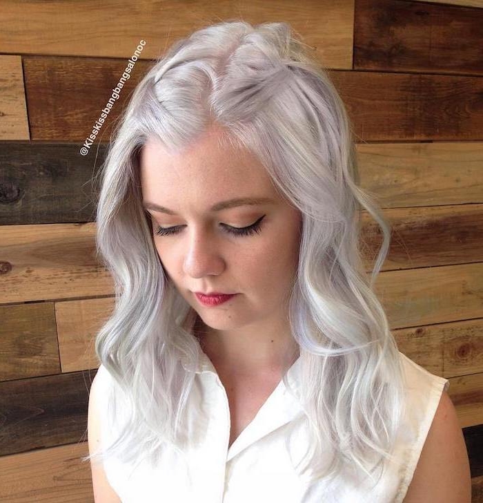 Haarfarbe Silberblond - ein junges Mädchen mit lässiger Frisur, das Mädchen hat eine weiße Bluse an