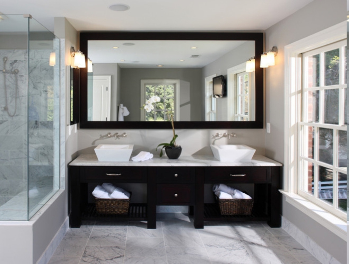 riesengroßer Wandspiegel mit Massivrahben über den beiden Waschbecken, Waschtisch mit zwei Becken, zwei Flechtkörbe für saubere Handtücher, zwei Wandlampen auf beiden Seiten des Spiegels