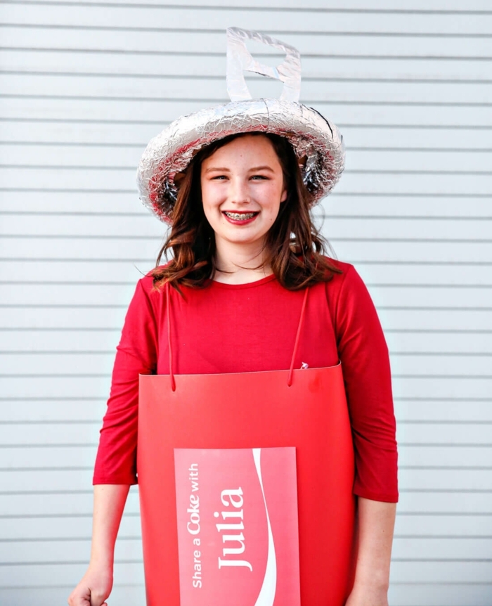 ein Teenager Mädchen mit rotem Kleid und Hut aus Folie stellt Coca Colla Dose dar - Last Minute Kostüm Fasching