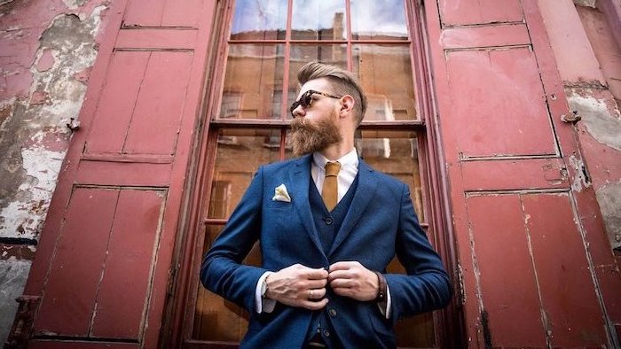 Hipster Bart Inspiration, schicker dunkelblauer Anzug mit weißem Hemd und hellbrauner Krawatte
