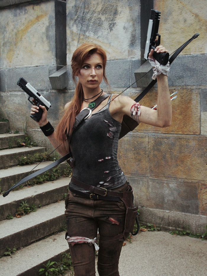 Lara Croft Tomb Raider Kostüm aus braunen zerrissenen Hosen mit zwei Ledergürteln und einem grauen zerrissenen Top mit Spaghetti-Trägern