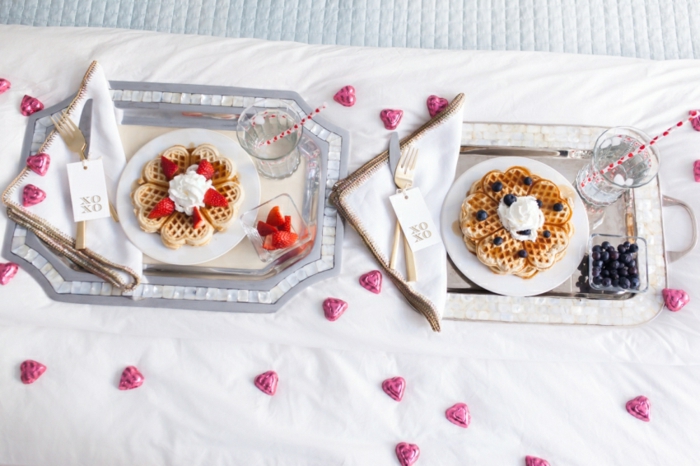 Frühstück im Bett zum Valentinstag, belgische Waffeln mit Sahne, Erd- und Blaubeeren, kleine Schokoladen Herzen