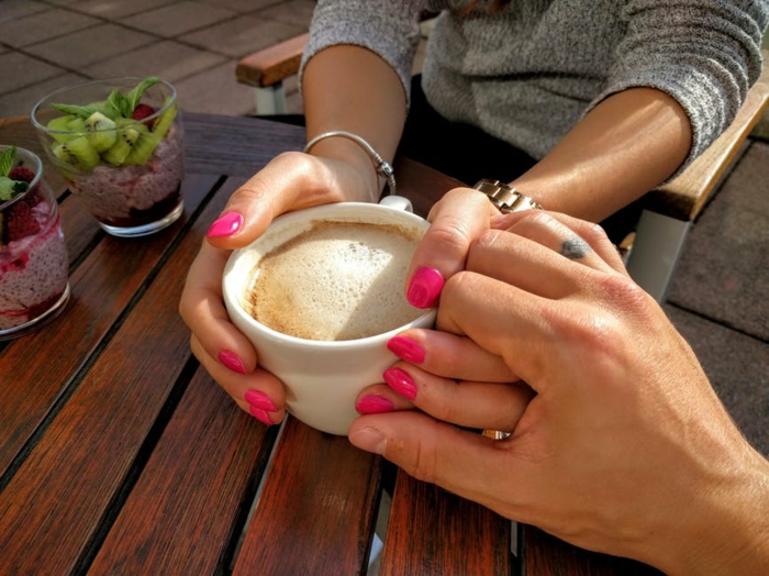 Kuschelbilder - zwei Verliebte halten Hände beim Frühstück zum Valentinstag