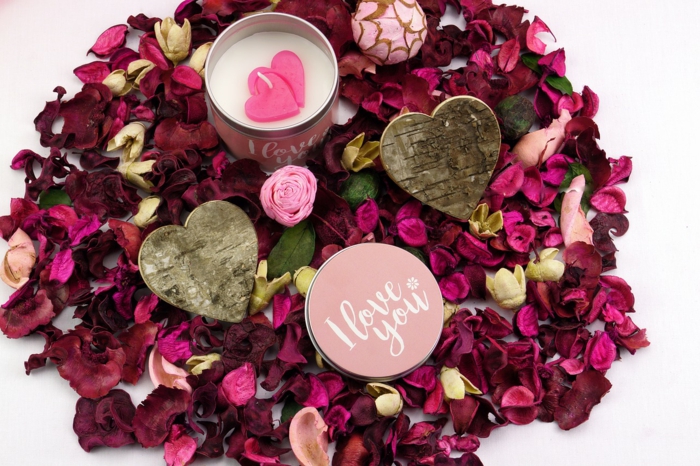 Dekoration zum Valentinstag - zwei Herzen aus Holz, eine Creme Ich liebe dich, Rosenblüten