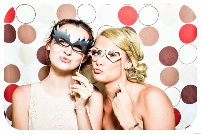zwei schöne Frauen mit Augenmaske zu einem Motto Kostümparty eingeladen