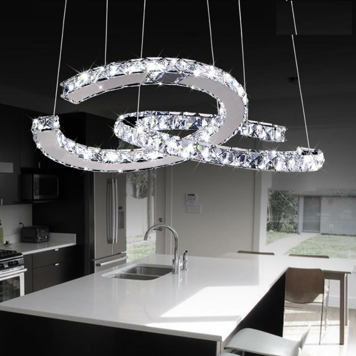 LED-Lampen in der Form von verflechteten Halbkreisen, schwarz-weiße Küche mit Kochinsel