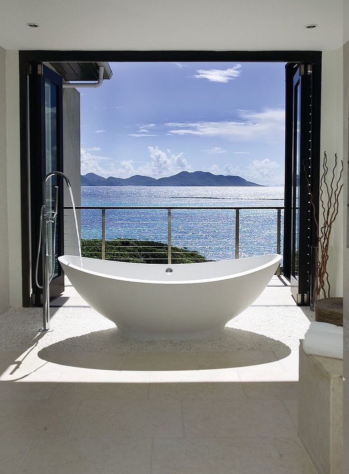 Meeres- und Gebirgeaussicht vom eigenen Bad, freistehende Badewanne vor dem Fenster, Terrasse mit zweiflügeliger Glastür, Deko aus Ikebanazweigen