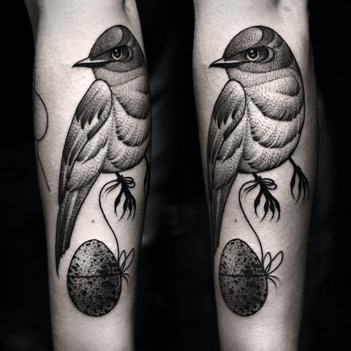schöne tattoos, schwarz-graue tätowierung am arm, vogel mit ei