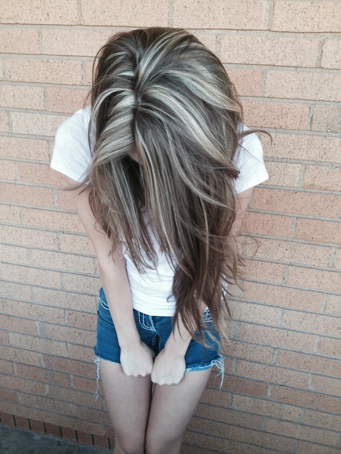 silberblonde Haare - ein Mädchen zeigt Ihr Haar, das mit silberblondem Strähnchen versehen ist