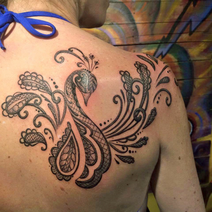 tattoo freiheit, frau mit großer abstrakter tätowierung, pfau-motiv