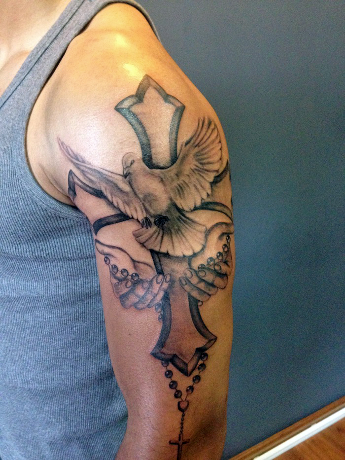 tattoo taube, mann mit großer 3d-tätowierung am arm, taube mit kreuz und hände
