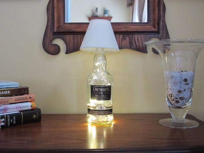 spiegel und ein tisch und eine diy lampe aus einer durchsichtigen glasflasche - lampen aus flaschen selber machen