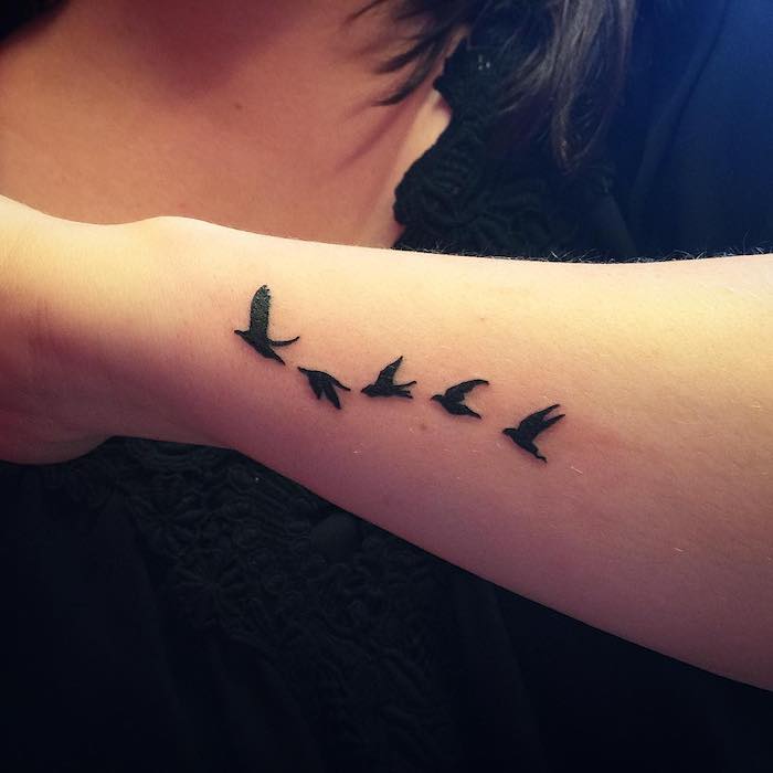 unterarm tattoo, kleine tattoo motive, schwarze fliegende vögel