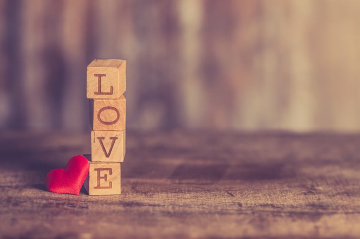 vier Würfel, die Love bilden und ein rotes Herz - Valentinstagsgrüße