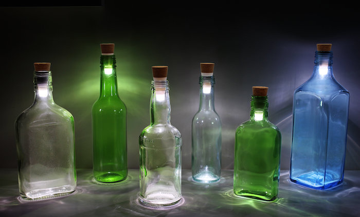 drei durchsichtige glasflaschen - flaschenlampen aus zwei grünen flaschen und einer großen blauen flasche - flaschenlampe selber bauen